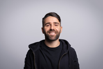 Fototapeta premium Smiling man with beard wearing black hoodie