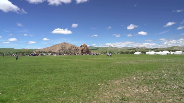Taikhar Rock monumental granite outcrop rising beside river valley landscape in central Mongolia. Monolith marks ritual heritage, pilgrimage appeal, steppe symbolism, cultural destination.