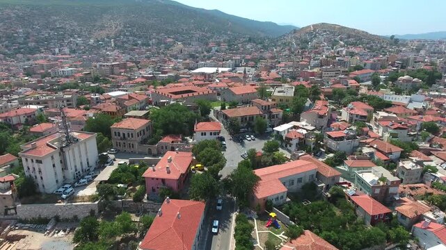 Aerial view shows traditional Milas town in Mugla with sunny roofs and historic houses. Anatolian settlement narrow streets reflect authentic urban heritage across summer terrain.