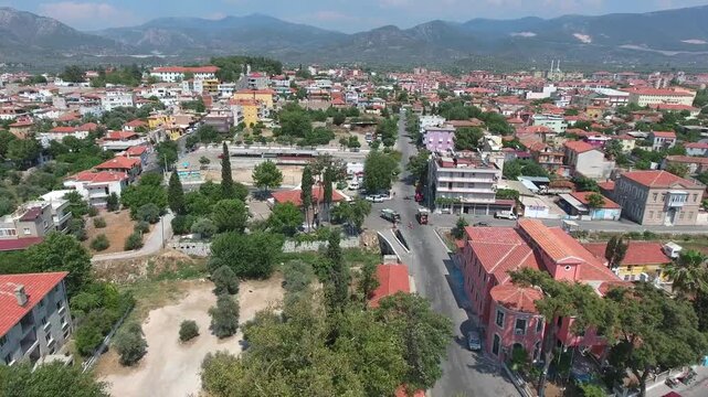 Aerial view shows traditional Milas town in Mugla with sunny roofs and historic houses. Anatolian settlement narrow streets reflect authentic urban heritage across summer terrain.