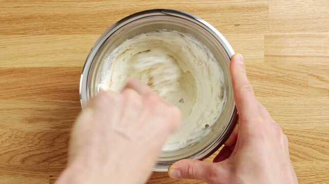 Chef's hands whisk ricotta in bowl in timelapse. Smooth cheese becomes mousse for elegant plated desserts and tartlets. Serve sweet ricotta cream with berries, figs, honey, chocolate or caramel.