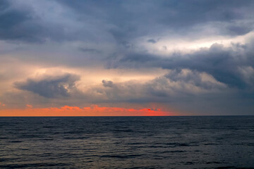 Fototapeta premium Scenic landscape of the sunset at the Black Sea, Batumi, Georgia. Sundown Above Sea Horizon At Sunset. Natural Sunrise Sky Warm Colors Over Ocean.