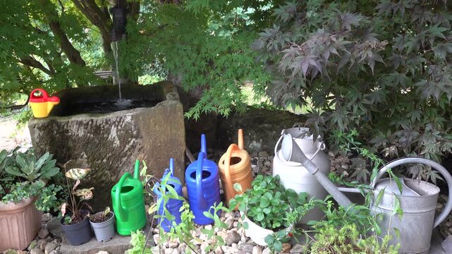 Gieskannen-Sammlung steht vor einem Wassertrog, Weilerswist, Nordrhein-Westfalen, Deutschland