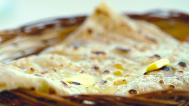 Naan bread on dark background close-up. Paratha and roti. Indian bread 4K video. Chapati and butter naan.