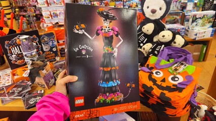 Obraz premium Potsdam, Germany - September 03, 2026: LEGO La Catrina building set displayed in a store, surrounded by Halloween decorations and plush toys on shelves