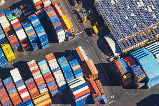 Aerial view of colorful shipping containers stacked in rows at the busy port terminal in La Spezia, Liguria, Italy.