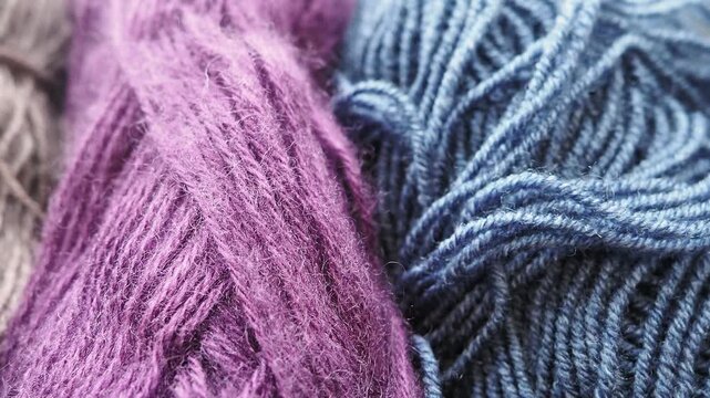 Dynamic close-up of woolen threads: the strands move gently to the left, creating a soothing, rhythmic visual effect. The rich texture and warm tone of the yarn evoke a sense of comfort and creativity