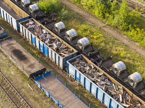 Aerial view of freight train cars loaded with steel coils and scrap metal on railway tracks in Poland.