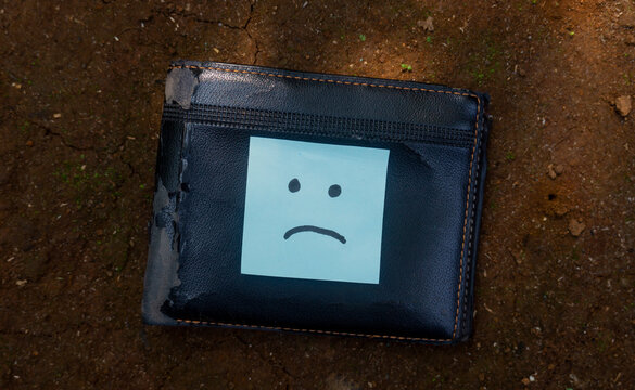 Sad Face Sticky Note on Black Wallet Financial Stress Concept, illustrating financial problems, money shortage, debt, or personal budgeting challenges.