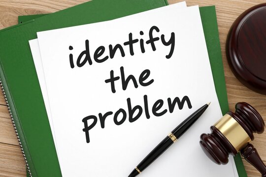White paper with text identify problem lies on green folder. Wooden judge gavel, black pen rest on desk. Legal concept about finding issues in law, court cases, crime investigation, contract disputes