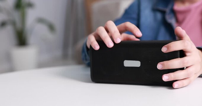 Woman using modern audio speaker at home, closeup