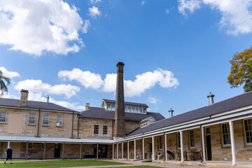 Fototapeta premium Sandstone courtyard featuring a central brick chimney against blue sky.