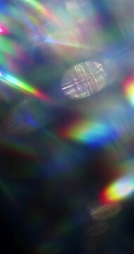 Light ray shining through a prism for beams of sparkling lights, shimmering bokeh, and a brilliant dazzling rainbow of lens flares. Visual effect of a light burst through swirling reflective glass.