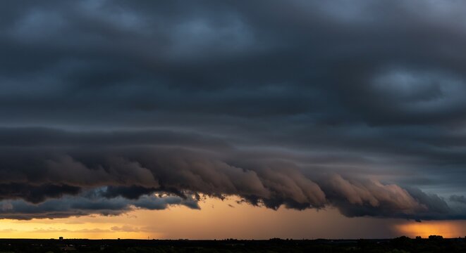 Impending Storm: Dark, ominous storm clouds gather on the horizon, casting a dramatic shadow over the landscape as rain begins to fall. A sense of anticipation and raw power fills the sky.
