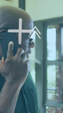 Animation of arrow and geometric shapes over senior man talking on smartphone