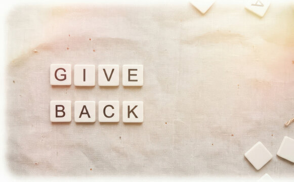 Give Back Concept Written With Scrabble Letter Tiles On Fabric Background For Charity And Volunteering Representation