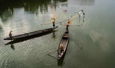 Throwing a fishing net on Nhu Y river, Hue, Vietnam. This is a river flowing through Hue city, where many Hue fishermen live.  © huong