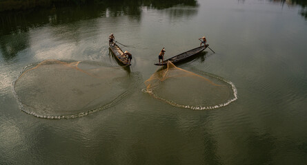 Throwing a fishing net on Nhu Y river, Hue, Vietnam. This is a river flowing through Hue city, where many Hue fishermen live.  © huong