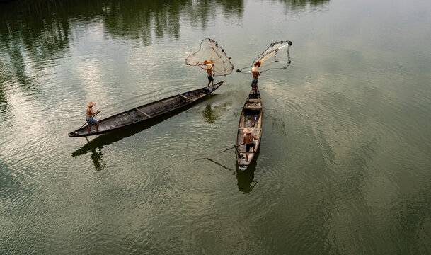 Throwing a fishing net on Nhu Y river, Hue, Vietnam. This is a river flowing through Hue city, where many Hue fishermen live. 