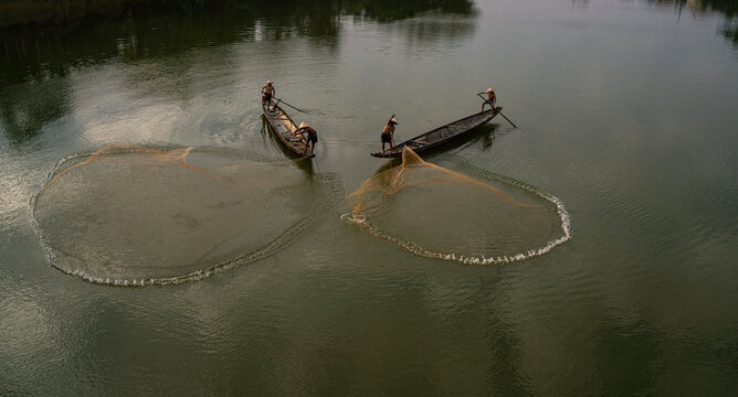 Throwing a fishing net on Nhu Y river, Hue, Vietnam. This is a river flowing through Hue city, where many Hue fishermen live. 