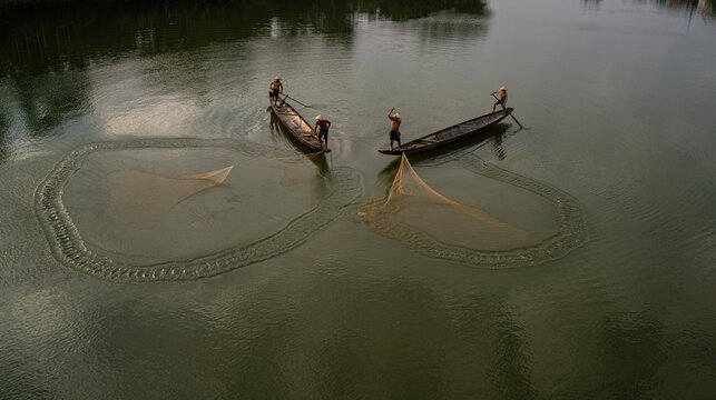 Throwing a fishing net on Nhu Y river, Hue, Vietnam. This is a river flowing through Hue city, where many Hue fishermen live. 