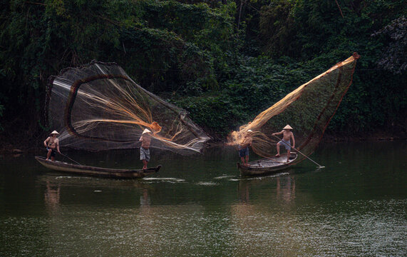 Throwing a fishing net on Nhu Y river, Hue, Vietnam. This is a river flowing through Hue city, where many Hue fishermen live. 