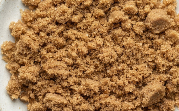 Macro closeup of moist brown sugar granules texture for baking ingredients and cooking recipes