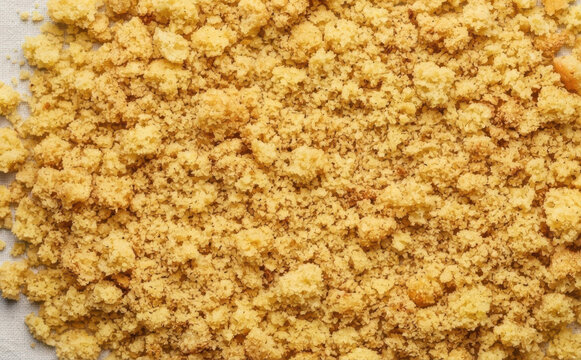 Golden cake crumbs and sweet cookie crumble texture background for baking and dessert concepts