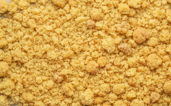 Crumbly streusel topping texture close up, sweet baking crumbs for dessert recipe background
