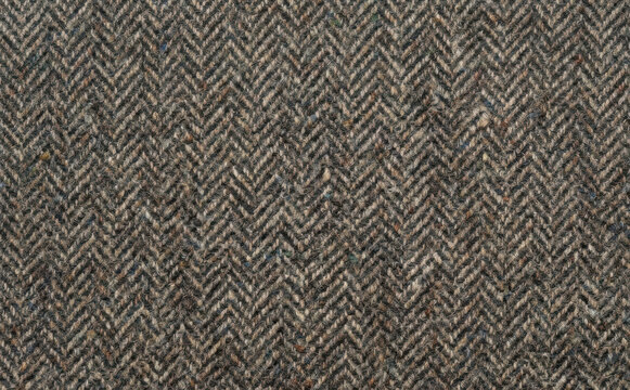 Brown tweed herringbone fabric texture pattern background close up macro photography of wool textile material for winter apparel and menswear design