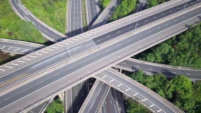 Aerial view of motorway highway interchange with complex flyover roads during daylight.