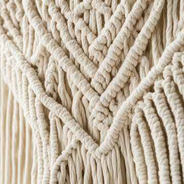 Handmade macrame wall hanging with intricate knot pattern on white wall, boho home decor lifestyle interior photography