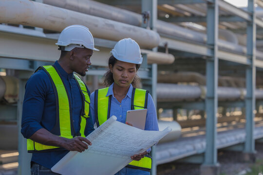 Engineer survey team checking construction project inspection work construction site .Team Civil engineer working outdoor next to the power plant.