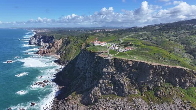 Aerial view of cabo da roca lighthouse on coastal cliffs in portugal during sunny day.
