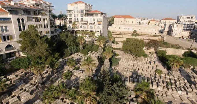 Aerial view rising over old cemetery and residential buildings in historic Jaffa Tel Aviv neighborhood of Israel.