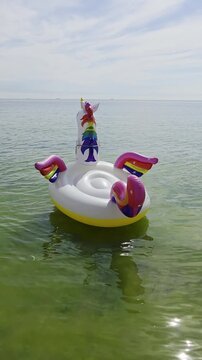 ​Inflatable rainbow unicorn float drifting on sea water