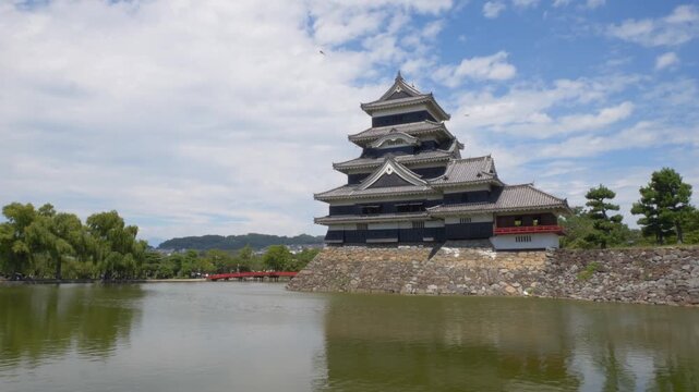 Matsumoto castle with scenic moat and bridge during bright summer day in Nagano Japan.