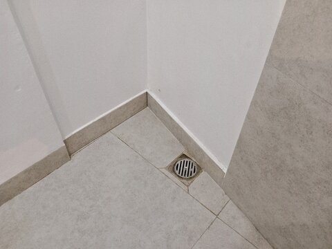 Stainless steel floor drain in bathroom showcasing modern plumbing, hygiene, and functional design.