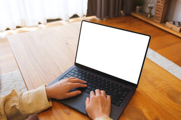 Mockup image of a woman working and typing on laptop computer with blank screen at home
