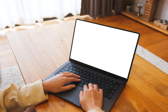 Mockup image of a woman working and typing on laptop computer with blank screen at home
