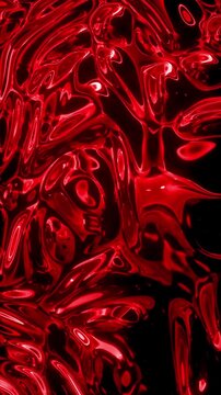 Abstract liquid red metallic surface rippling in constant flowing motion.