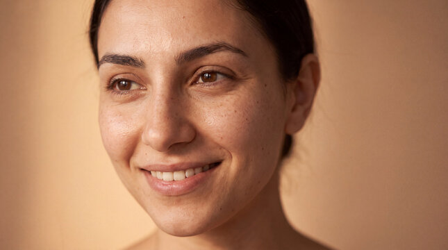 National Healthy Skin Month three-quarter portrait of a young Middle Eastern woman with dewy bare skin for makeup-free beauty blogs.