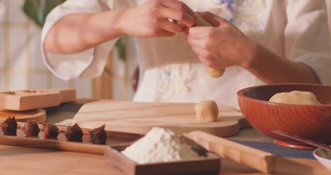Brushing egg liquid on handmade mooncake for Mid‑Autumn Festival