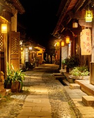 Fototapeta premium Empty cobblestone alley lit by lanterns at night, Shaxi Ancient Town, Yunnan, China