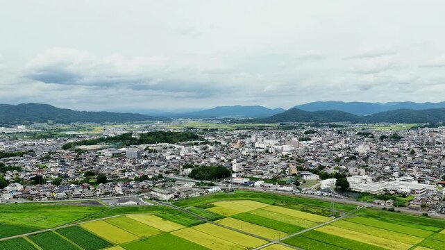 Aerial drone footage over urban area and rice fields in Iga, Mie, Japan