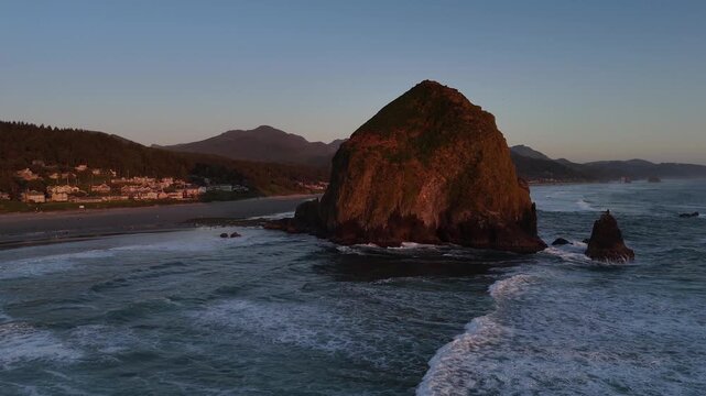 Haystack Rock and Coastal Town of Cannon Beach with Pacific Ocean Waves aerial drone 4k video