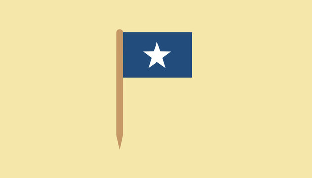 Tiny toothpick flag with blue color and white star in the center standing against a plain cream background.