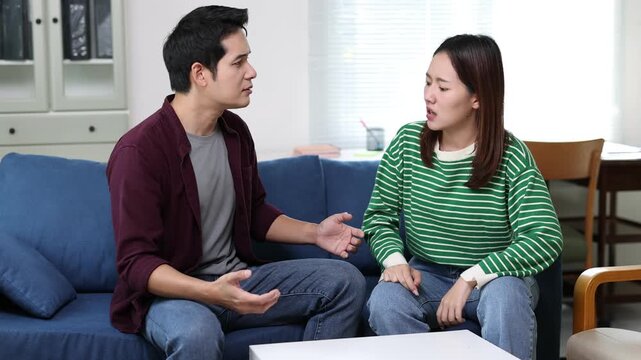 Young couple arguing about financial problems, showing empty wallet and unpaid bills on the table.