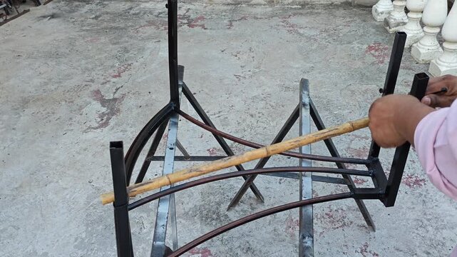 Attaching Zip Tie to Bind Bamboo Rod onto Metal Frame Structure