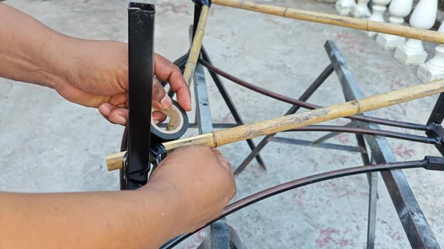 Binding Bamboo Rods to Iron Structure Using Black Electrical Tape
